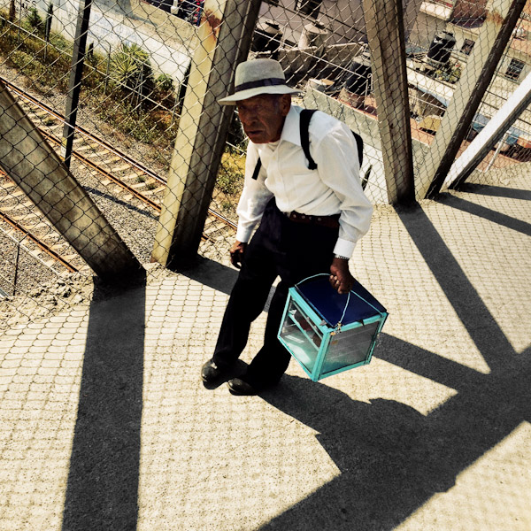 An old Mexican man carries a glass box with home maded cakes for sale in Lechería, a suburb of Mexico City, Mexico.