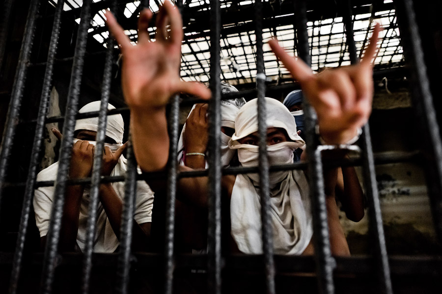 The Mara Salvatrucha gang members show finger signs representing their gang while being detained in the cell of a detention center in San Salvador, El Salvador.