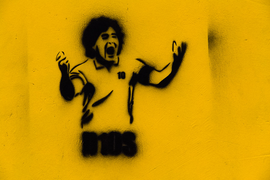 A spray and stencil artwork, depicting legendary Argentine football player Diego Maradona (D10S), appears on the street of San Jose, Costa Rica.
