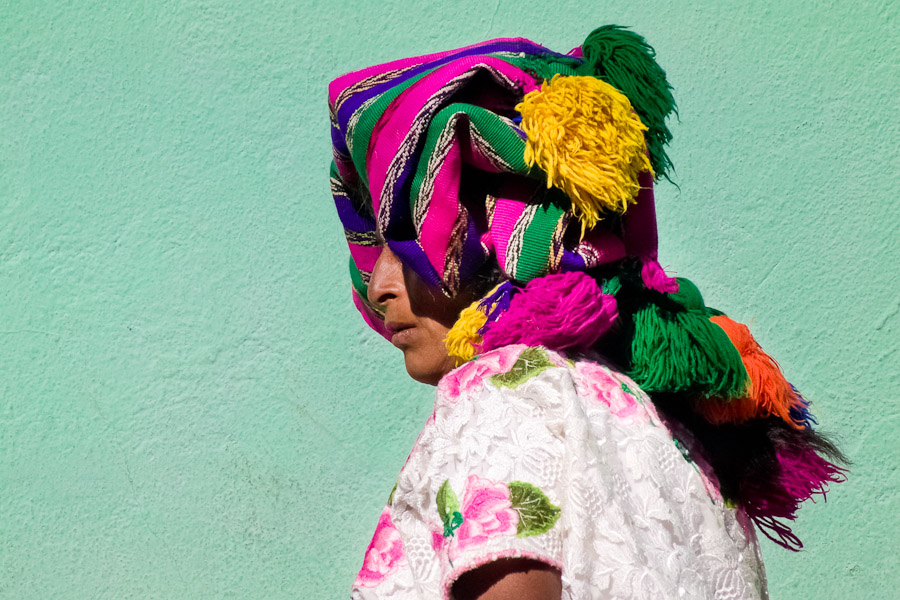 A Maya woman wearing a colorful hand woven headscarf stands in the market of San Francisco El Alto, Guatemala.