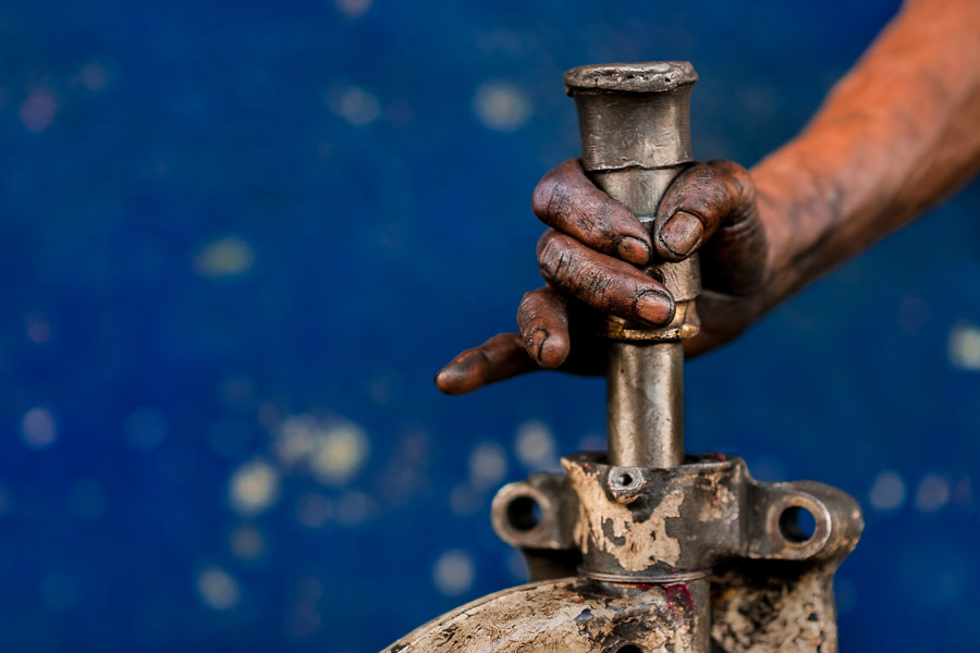 A Colombian mechanic works on an old truck’s solid axle in a car repair workshop in Barrio Triste, Medellín, Colombia.