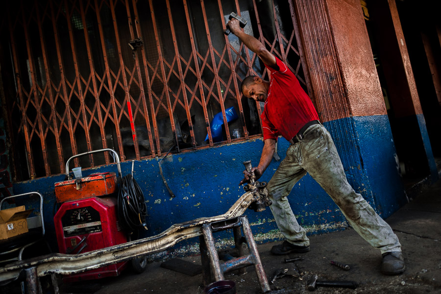 Colombian car mechanics work in a car repair shop in Barrio Triste, Medellín, Colombia.