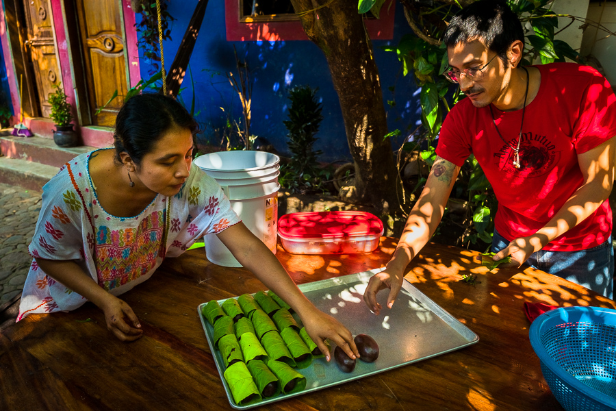 An Amuzgo indigenous woman, together with her husband, wraps chocolate balls made of raw cacao paste into cacao tree leaves in artisanal chocolate manufacture in Xochistlahuaca, Guerrero, Mexico.