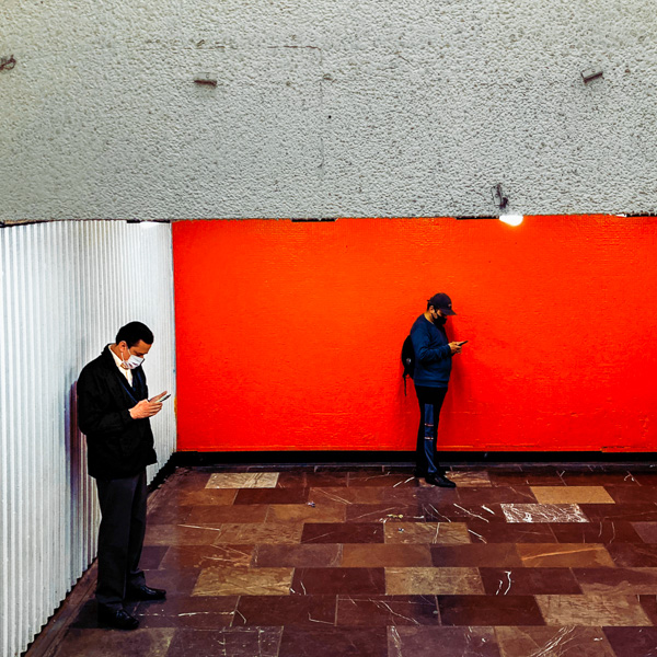 Mexican men look at the phone screens while waiting for subway in Mexico City, Mexico.