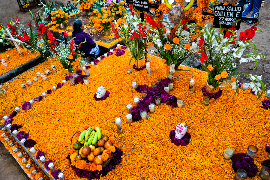 A Mexican woman sits at the flower-decorated gravesite to honor her deceased relatives during the Day of the Dead celebration in Tzintzuntzan, Michoacán, Mexico.