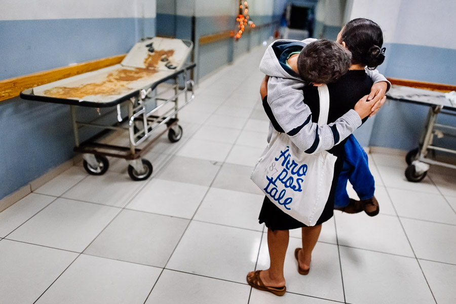 A Salvadoran woman carries his ill son while seeking an urgent medical help in the emergency department of a public hospital in San Salvador, El Salvador.