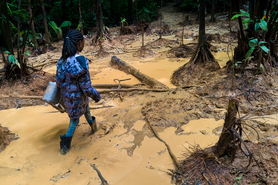 A Nigerian migrant child walks through a muddy trail in the wild and dangerous jungle of the Darién Gap between Colombia and Panamá.