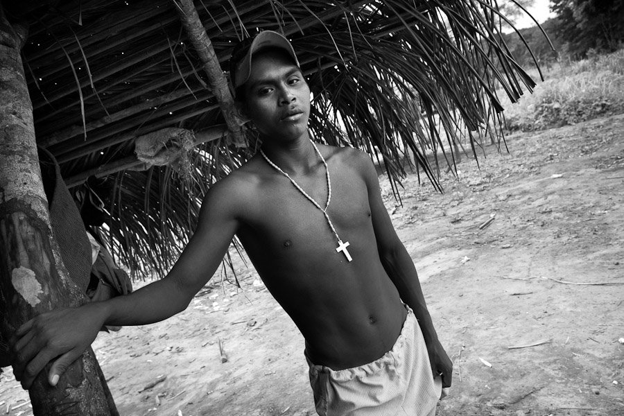 The young Nukak boys from refugee camps, influenced by Colombian colonists and missionaries, often adopt Christian symbols and proudly wear them.