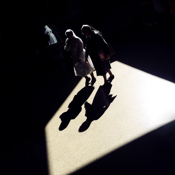 Colombian nuns walk through a beam of light thrown on the platform of San Antonio metro station in Medellín, Colombia.
