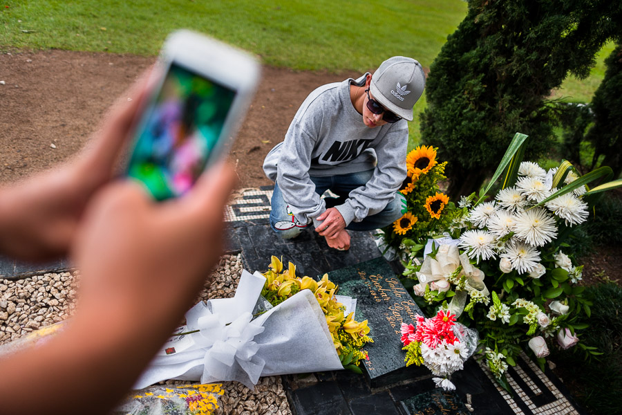 Young Colombian men take snapshots of themselves while visiting the tomb of the drug lord Pablo Escobar at the cemetery of Montesacro, in Itagüí, Colombia.