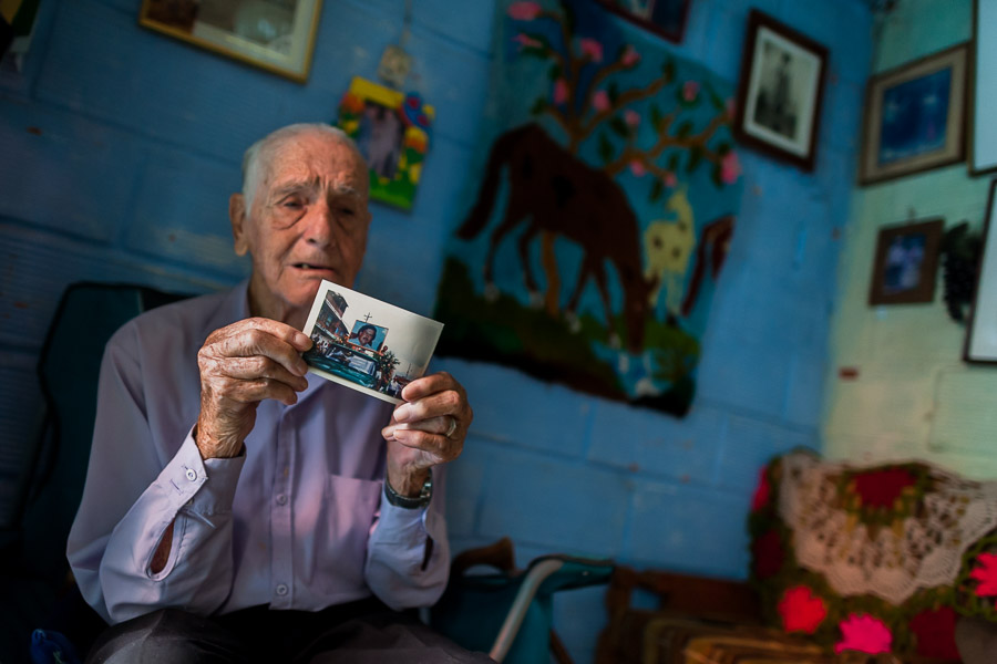 Francisco Flores, one of the first inhabitants of the Pablo Escobar neighborhood, shows a picture taken at Pablo Escobar’s funeral, in Medellín, Colombia.