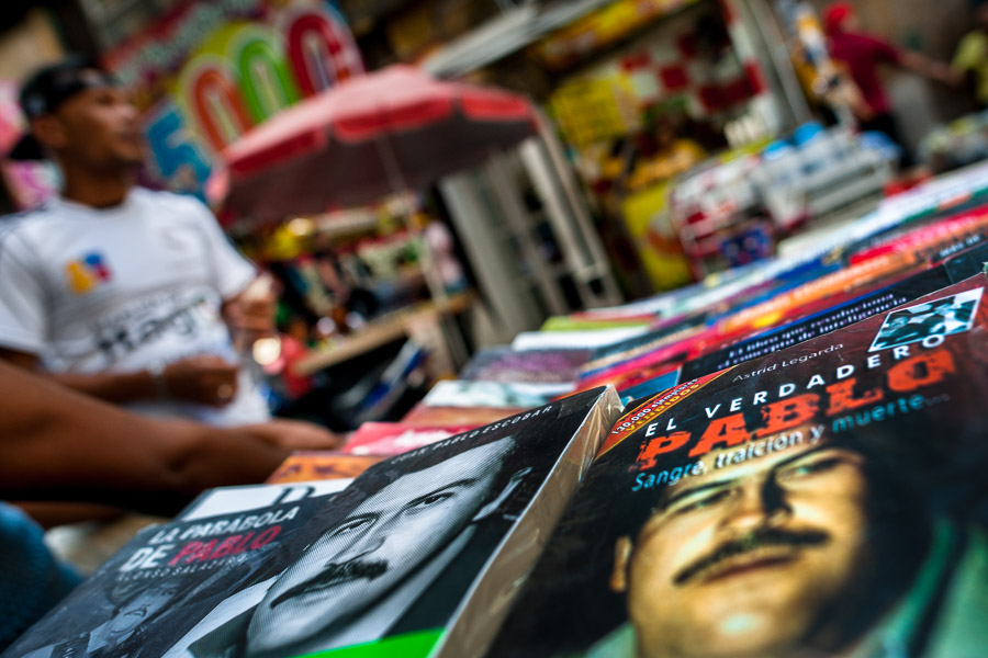 Paperback books, depicting the drug lord Pablo Escobar on their covers, are seen arranged at the market stand on the street in Medellín, Colombia.