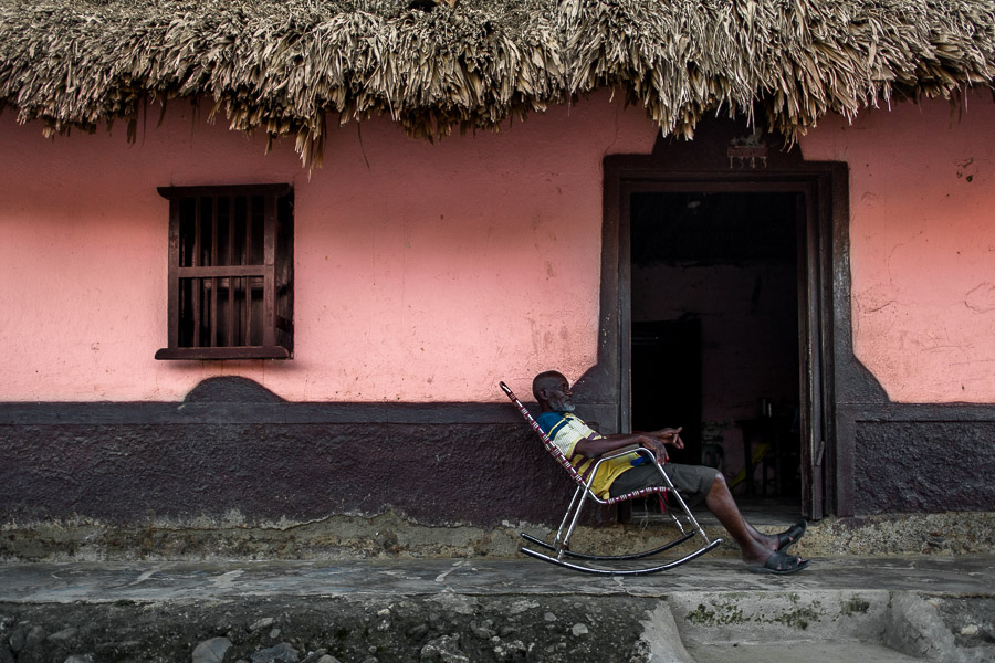 An old Colombian man sits in a rocking chair in front of his house in San Basilio de Palenque, a village in the Caribbean region of Colombia.