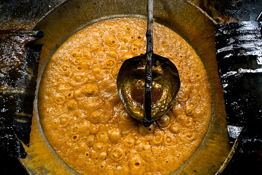A boiling sugar cane juice seen during the processing of panela in a rural sugar cane mill in Valle del Cauca, Colombia.