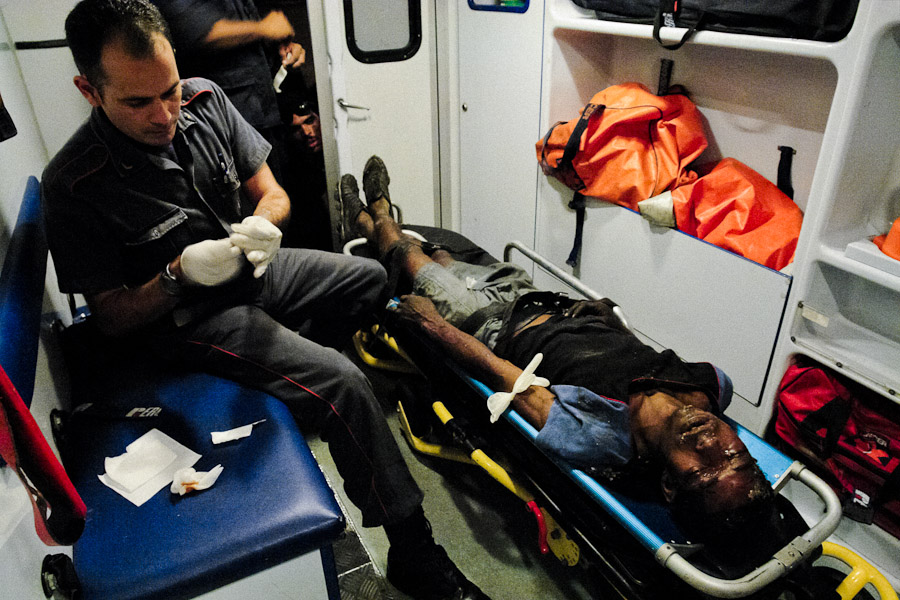 Venezuelan paramedics, members of the Caracas emergency medical service, try to save life of a homeless drug addict inside the ambulance car during the night in Caracas.