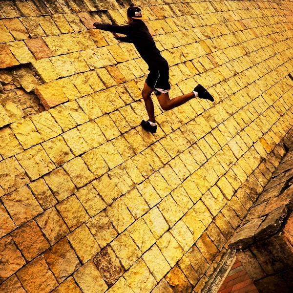 A Colombian parkour runner jumps on the wall during a free running training session held in a park in Kennedy, Bogotá, Colombia.