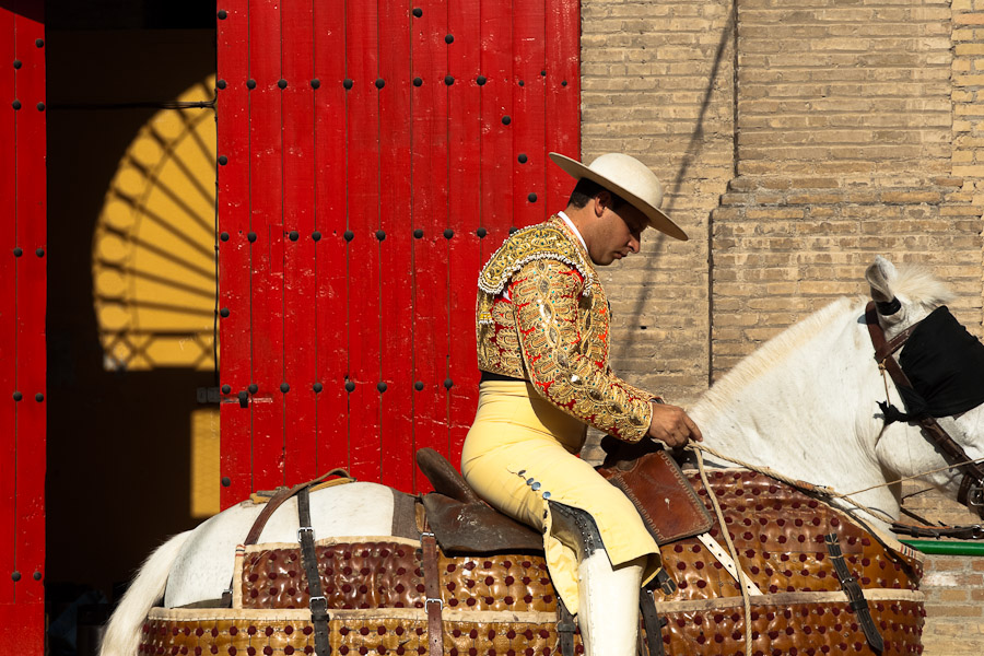 A Spanish bullfighter (picador) prepares his horse in front of the bullring.