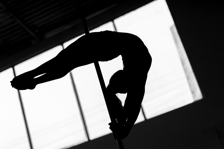 A young Colombian pole dancer demontrates her gymnastics skills during a pole dance training session in a gym in Bogotá, Colombia.