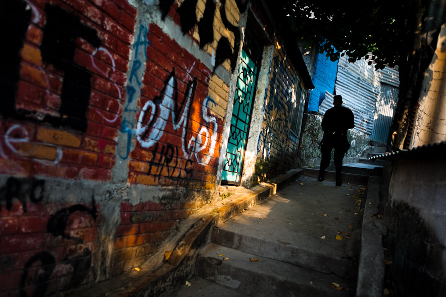 A policeman from the special emergency unit (Halcones) chases supposed gang members in a gang neighbourhood of San Salvador, El Salvador.