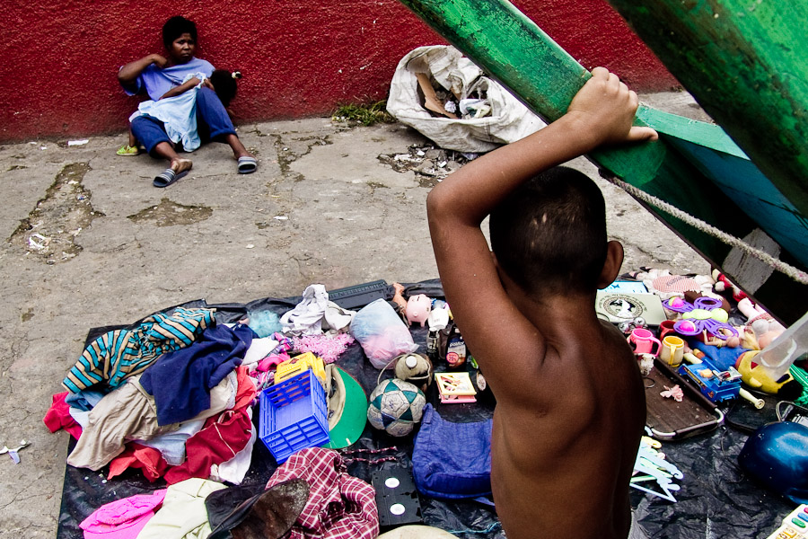 A young unmarried mother with her babygirl sells rummage and used clothes found in the garbage dumps along the nearby commercial district streets.