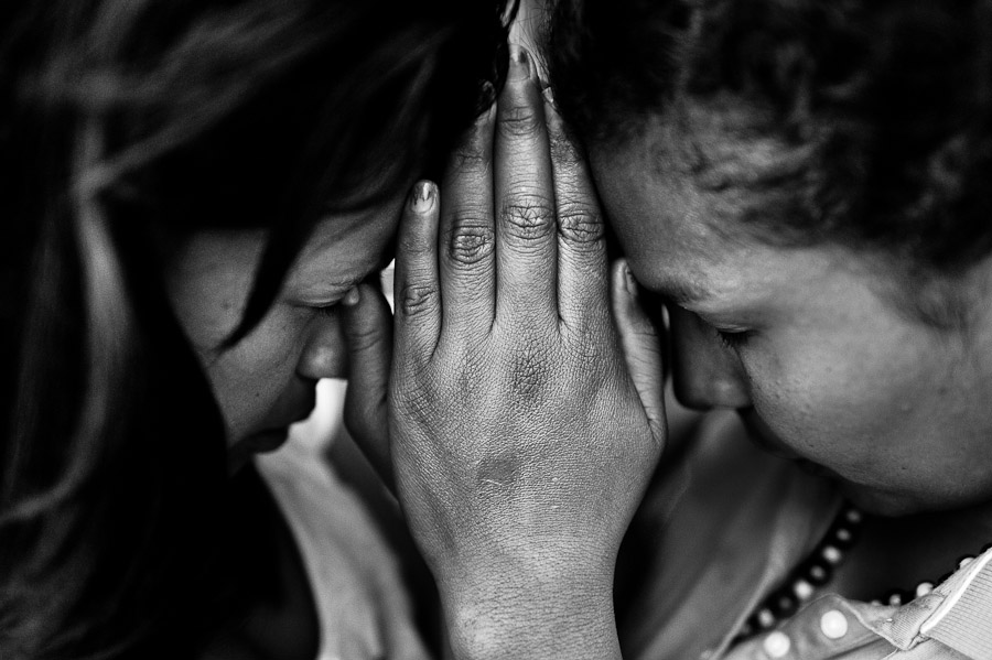 Colombian women, having joined hands, pray during the religious healing ceremony performed at a house church in Bogota, Colombia.