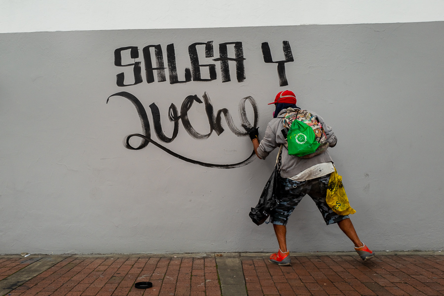 A radical student of the Universidad Nacional de Colombia paints a political slogan on the wall during a protest march against government’s policies and corruption within the public educational system in Bogotá, Colombia.