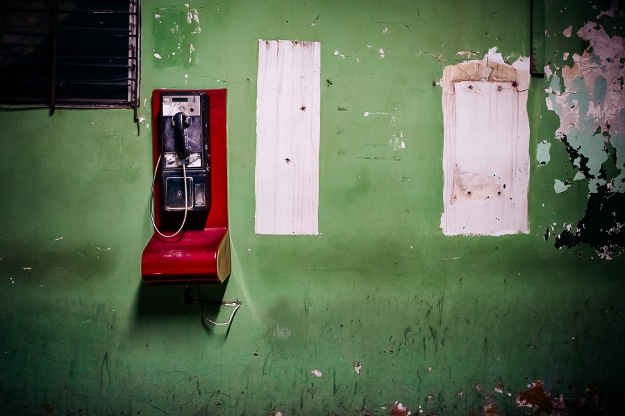 A public pay phone is seen hung on the wall in a patio inside the emergency department of a public hospital in San Salvador, El Salvador.