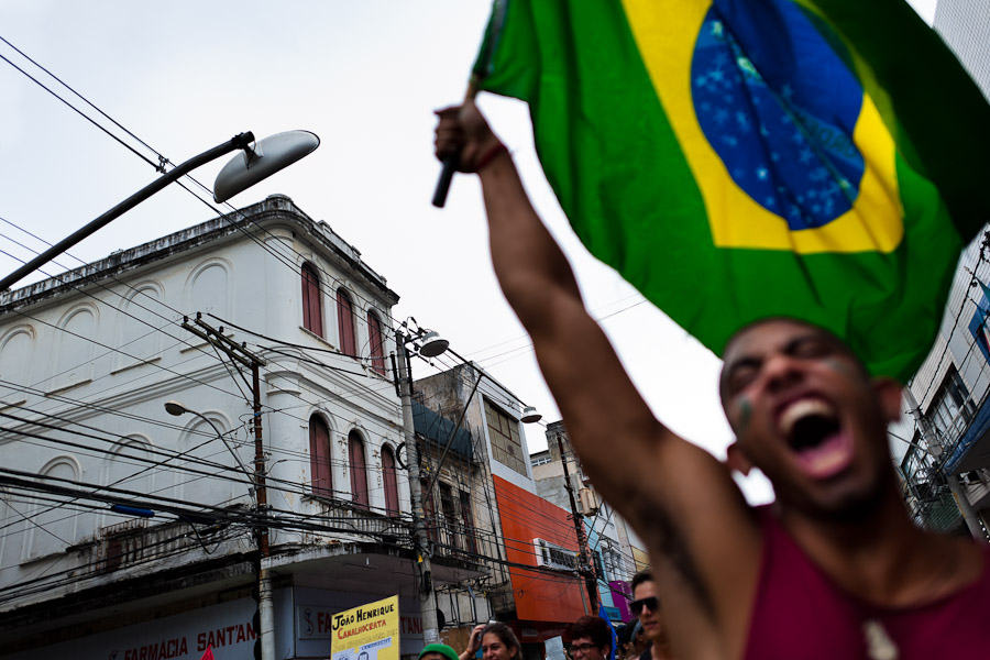 A radical protester, holding the Brazilian flag, screams during the protest march in Salvador, Bahia, Brazil.