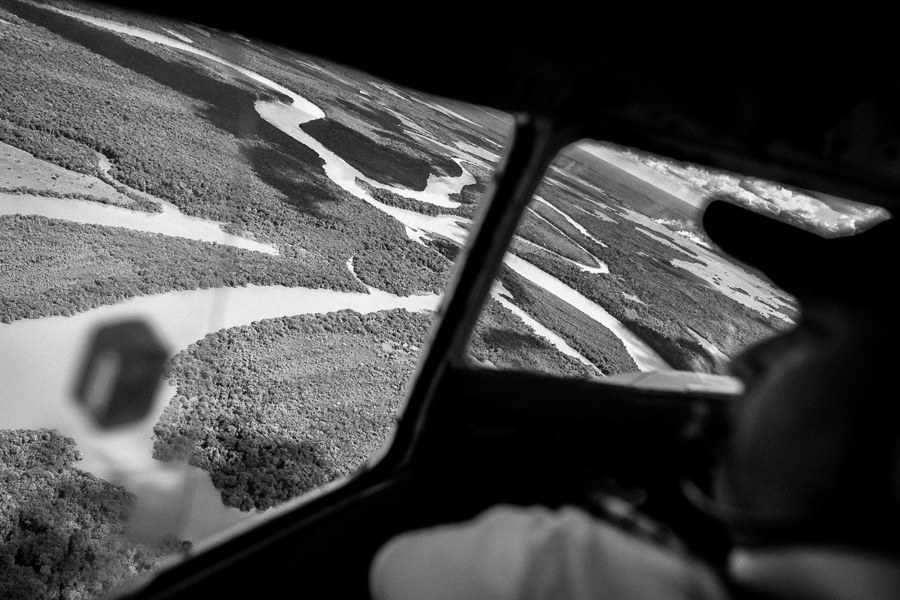 Vast expanses of Amazonian tropical rainforest, traversed by rivers and canals, are seen from the cockpit of a Douglas DC-3 aircraft, landing in the remote department of Guainía, Colombia.