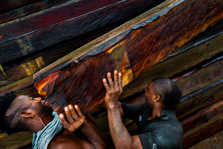 Afro-Colombian carriers (coteros) lift a rough sawn timber, extracted from the Pacific rainforest, during wood transportation in the port of Turbo, Colombia.