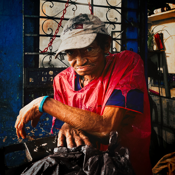 A Colombian worker wears a torn plastic sack to protect himself from a heavy downpour during the annual rainy season in Cartagena, Colombia.