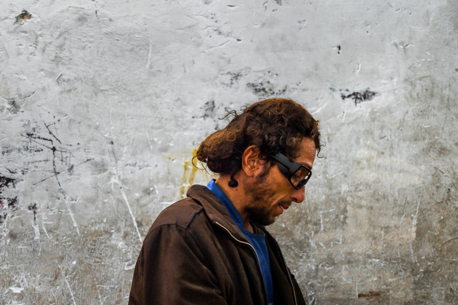 A Colombian drug consumer unloads a street-collected waste in a recycling warehouse in Medellín, Colombia.