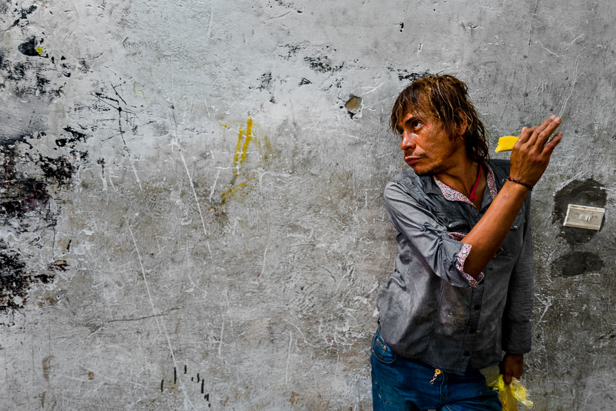 A Colombian drug consumer poses for a picture while unloading a street-collected waste in a recycling warehouse in Medellín, Colombia.