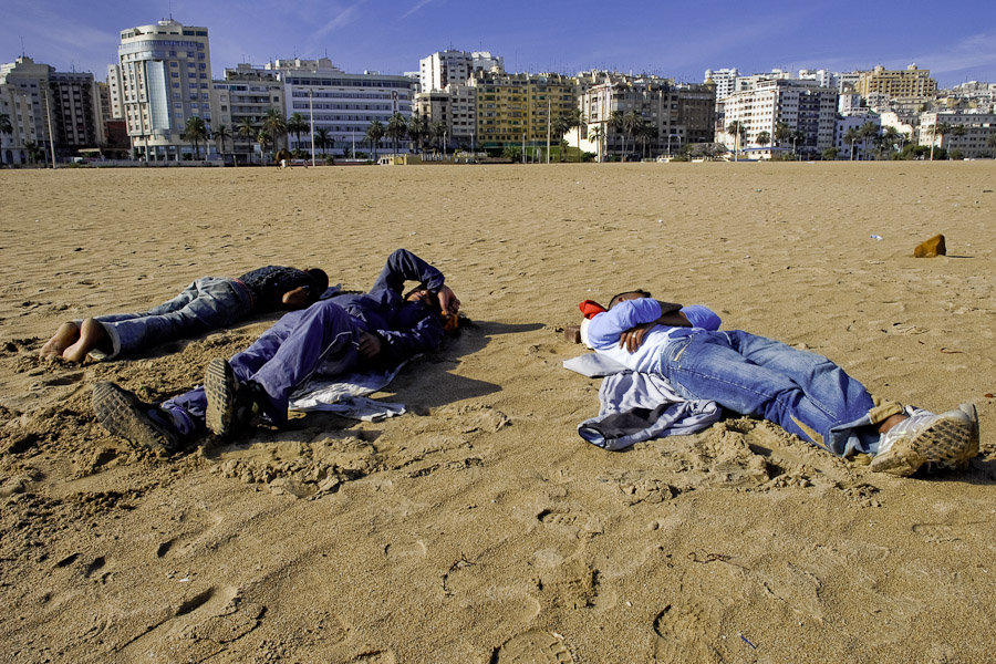 Harraga refugees sleep on the beach of Tanger after a busy night when they were trying to get inside the port and escape illegaly from Morocco.
