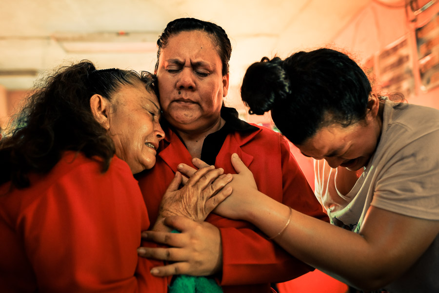 Christian followers, members of a local religious cult, cry desperately during the religious exaltation in a home church in San Salvador, El Salvador.