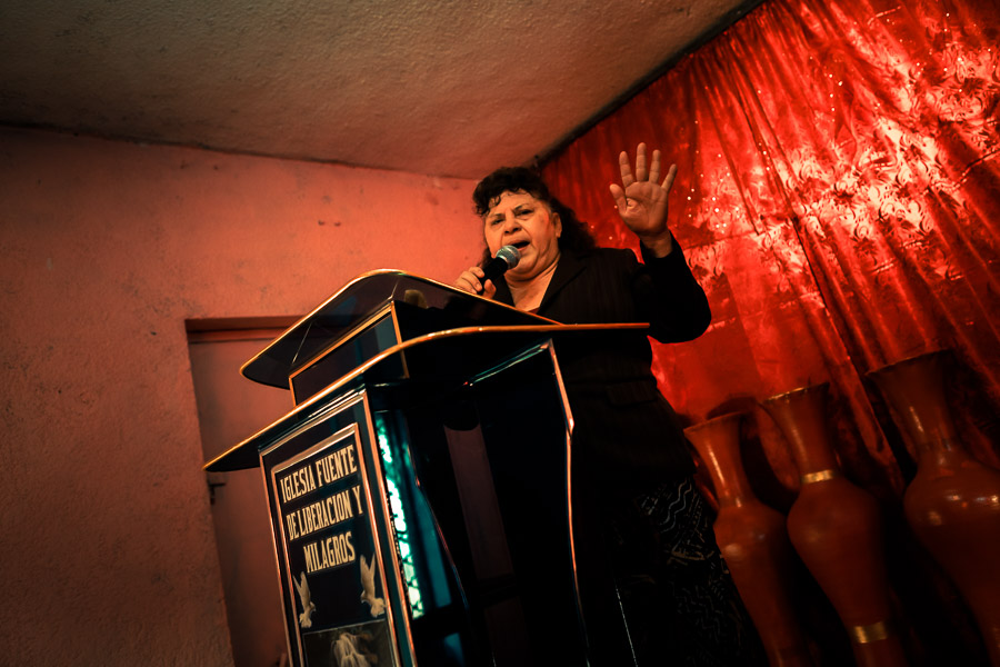A Christian follower, the pastor of a local religious cult, preaches to devotees during the religious ritual in a home church in San Salvador, El Salvador.