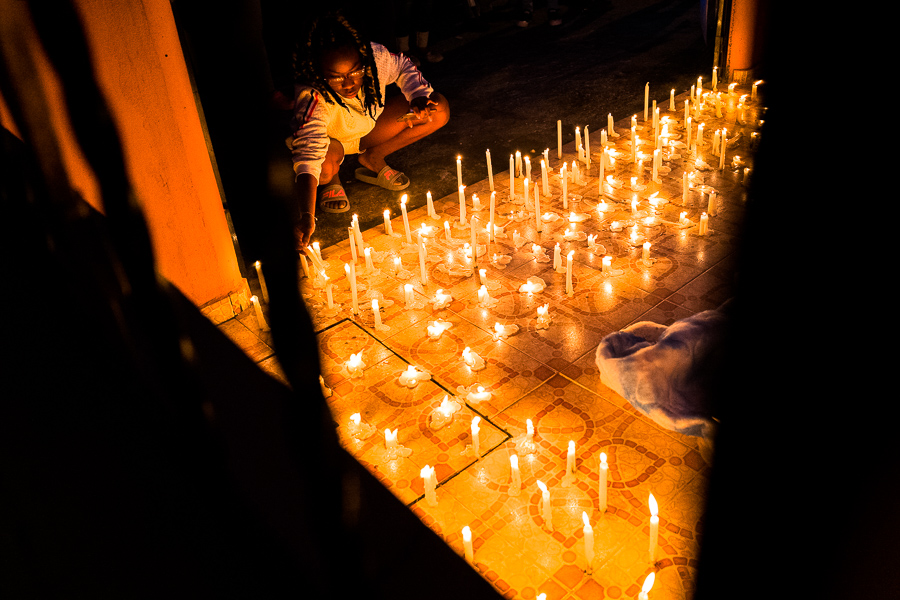 An Afro-Colombian Catholic follower lights a candle while taking part in a religious procession during the San Pacho festival in Quibdó, Colombia.