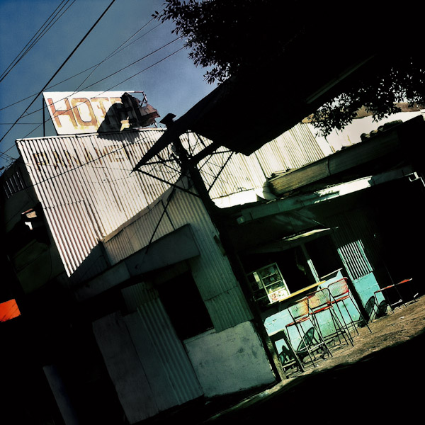 A rusty hotel sign seen on the roof of a sheet metal house in the center of San Salvador, El Salvador.