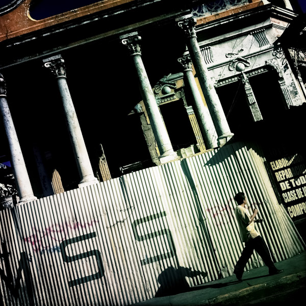 A Salvadorean man walks along a ruined colonial building on the street of San Salvador, El Salvador.