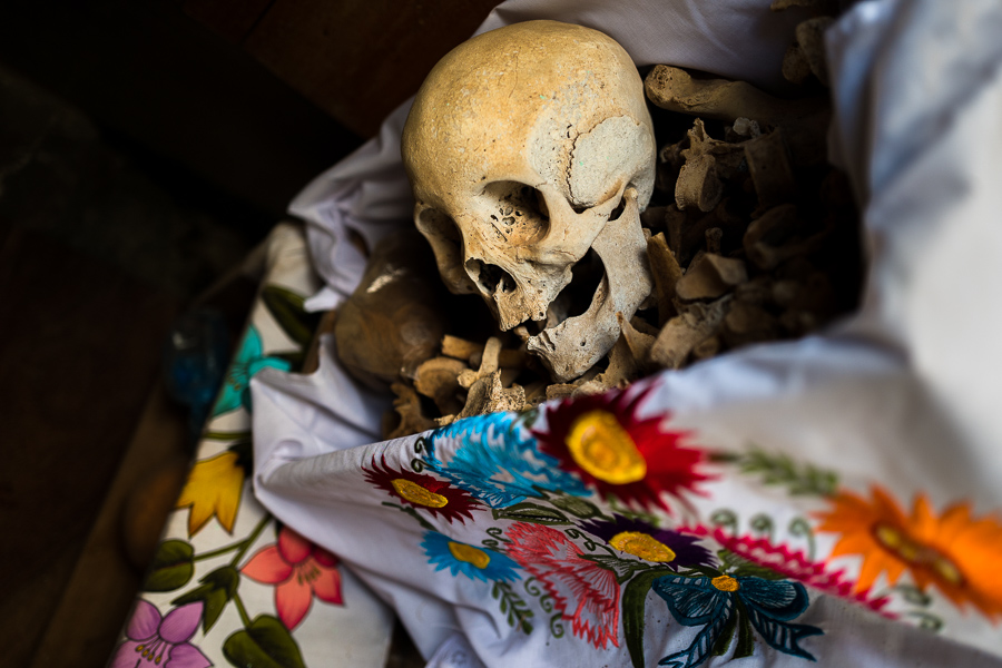A dried-up scull and bones are seen wrapped in an embroidered cloth and placed in a wooden crate inside a niche at the cemetery in Pomuch, Mexico.