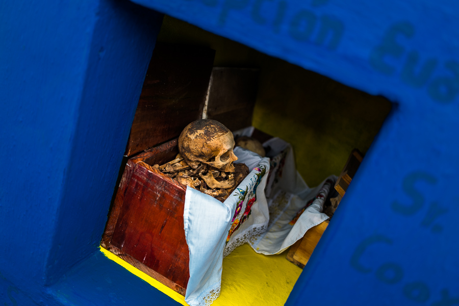 A dried-up scull and bones are seen wrapped in a cloth and placed in a wooden crate inside a niche at the cemetery in Pomuch, Mexico.
