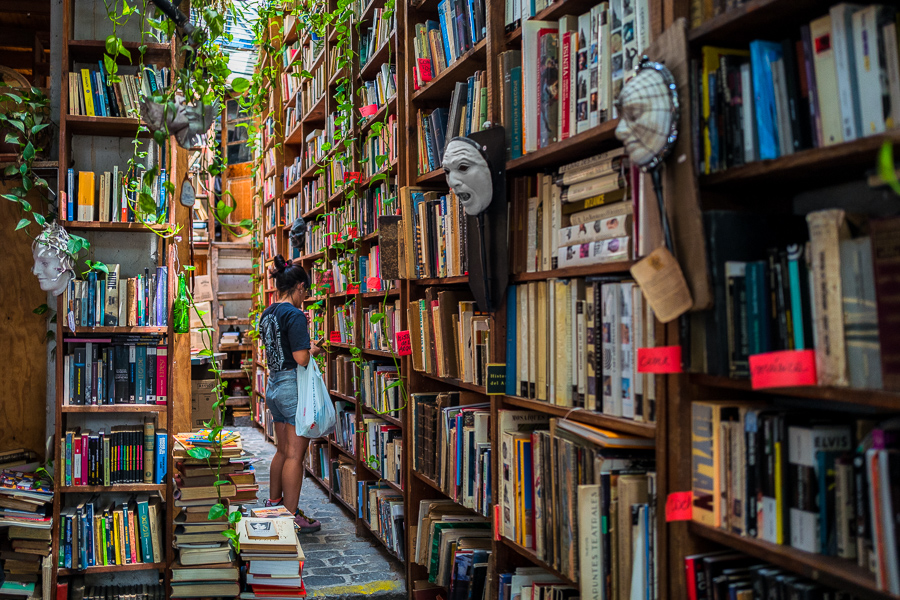 A young Uruguayan woman looks through old books on the shelves in a secondhand bookstore at the Tristán Narvaja street market in Montevideo, Uruguay.