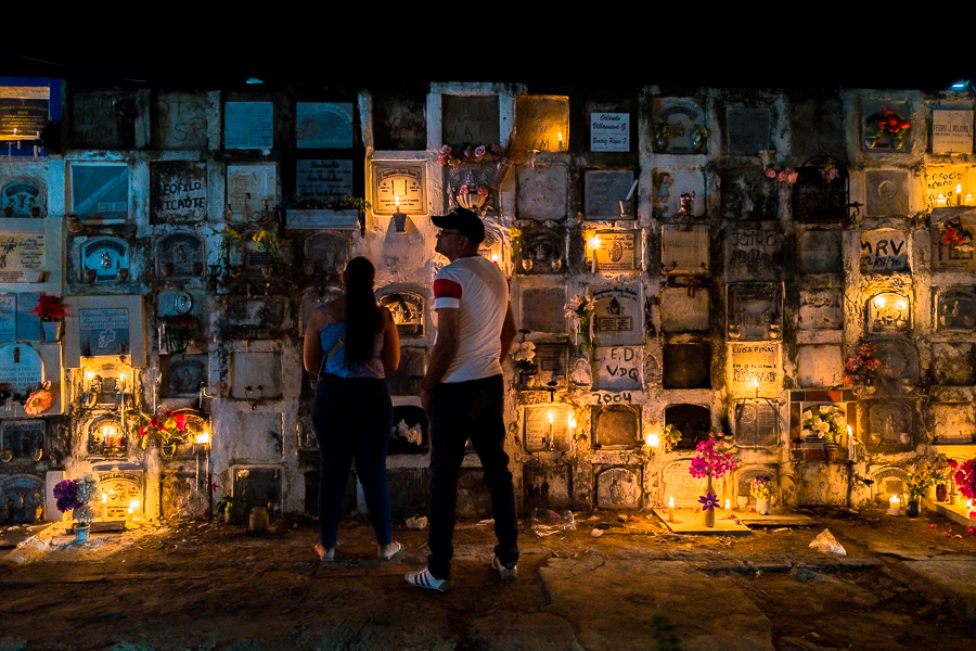 A Colombian couple prays in front of a columbarium in remembrance of their deceased relatives during the Holy Week celebrations at the cemetery in Mompox, Colombia.