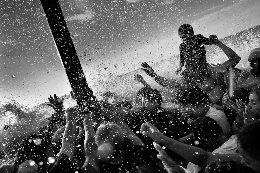 The sacred wooden cross is sprayed by water in the sea during the annual Holy Week ritual.