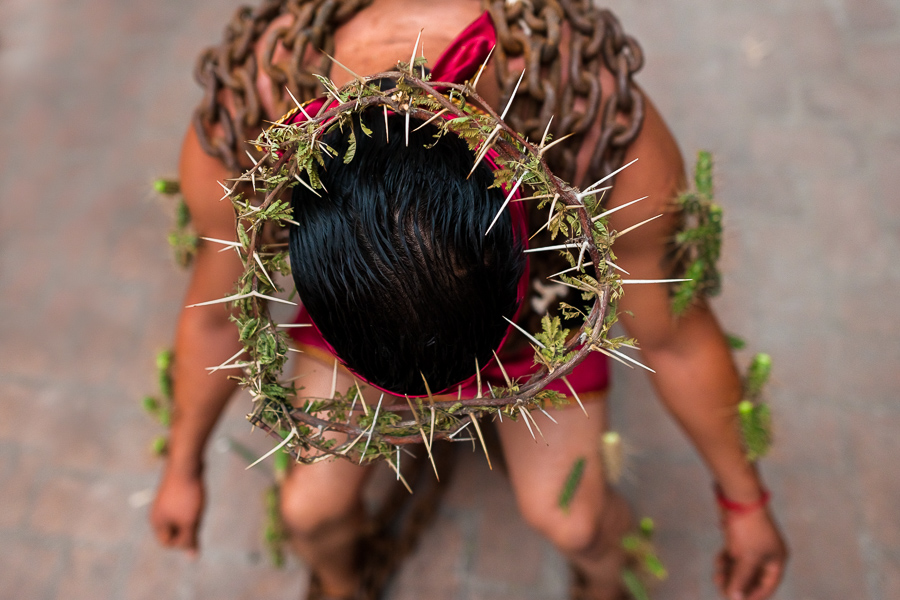 A chained Catholic penitent, wearing crown of thorns and cactus spines stuck to his body, prepares to participate in the Holy week procession in Atlixco, Mexico.