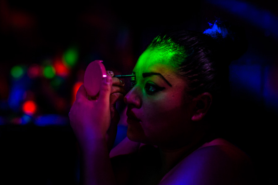 A Salvadoran sex worker applies makeup before beginning a work shift in a sex dance club in San Salvador, El Salvador.