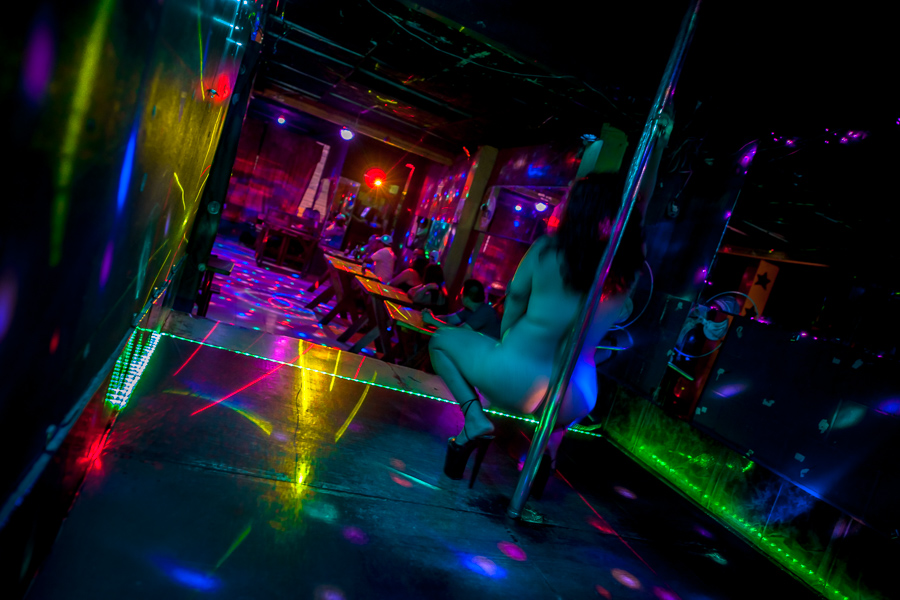 A Salvadoran sex worker performs erotic pole dance on the stage in a sex club in San Salvador, El Salvador.