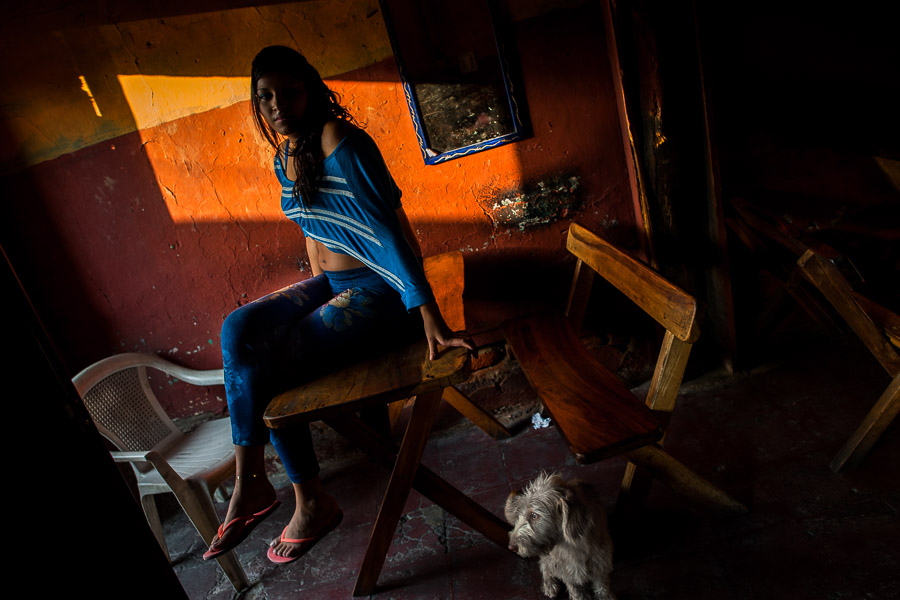 A Salvadoran sex worker poses for a picture with her dog pet while waiting for clients in a street sex bar in San Salvador, El Salvador.