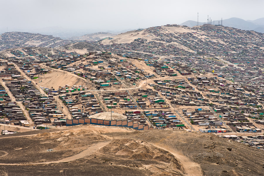 A sprawling settlement of houses and wooden shacks is seen on the dusty hillsides of Pachacútec, a desert suburb of Lima, Peru.