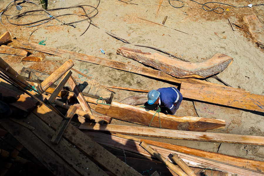 An Ecuadorian shipbuilding worker builds a traditional wooden fishing vessel in an artisanal shipyard on the beach in Manta, Ecuador.
